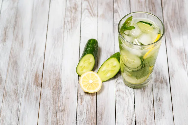 Water met citroen, munt en komkommer op houten lichte achtergrond. Water Detox. — Stockfoto