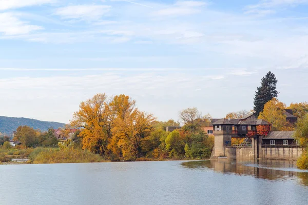 Herbstlicher Fluss, bunte Bäume am Wasser im Dorf. — Stockfoto