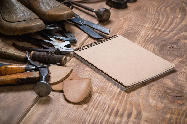 Σύνολο εργαλείων και σημειωματάριο για τσαγκάρης σε φόντο ξύλινη. — Φωτογραφία Αρχείου