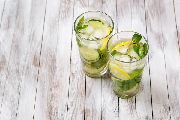 Water with lemon, mint and cucumber on wooden light background. Water Detox. — Stock Photo, Image