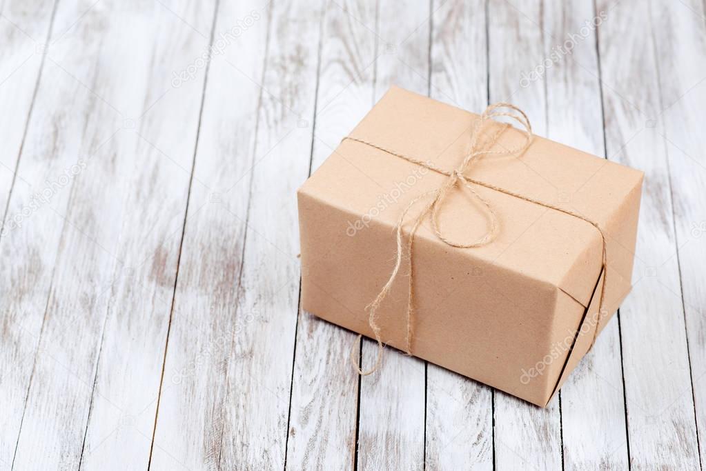 Gift boxes with kraft paper over wooden background.