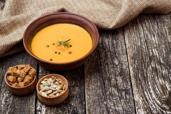 Cuenco de sopa de calabaza con pan crouton en mesa de madera oscura . — Foto de Stock