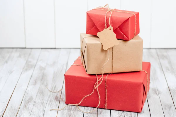 Drie gift vakken met tag over houten achtergrond. — Stockfoto