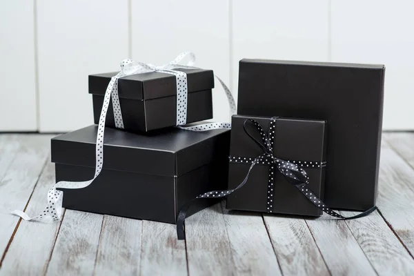 Cajas de regalo negras sobre fondo de madera . — Foto de Stock