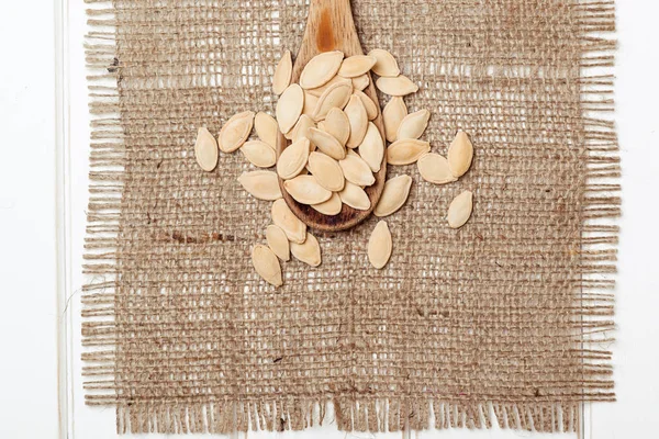 Semințe de dovleac într-o lingură pe masa de lemn . — Fotografie, imagine de stoc