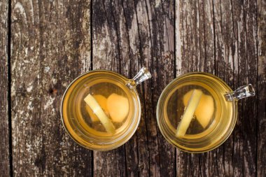 Ahşap arka plan üzerinde limonlu zencefil çayı. Üstten Görünüm. Metin için yer.