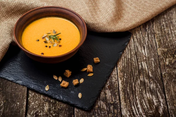 Sopa de calabaza con pan crouton en la mesa de madera oscura . — Foto de Stock