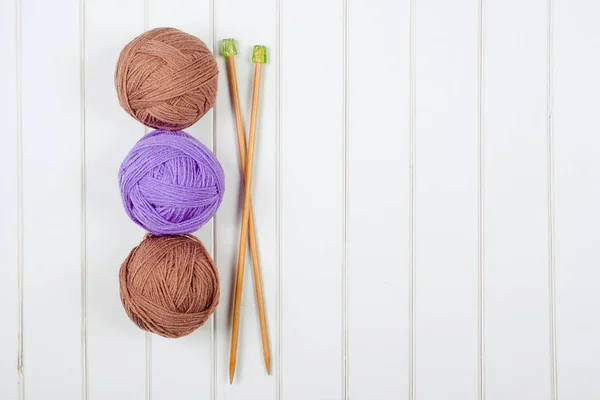 Knitting yarn balls and needles on the white wooden background. — Stock Photo, Image