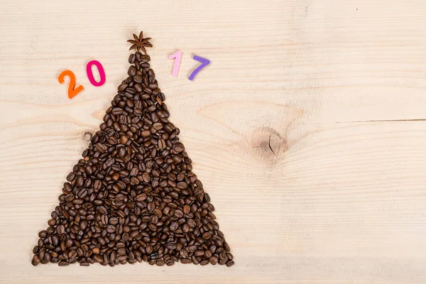 Χριστουγεννιάτικο δέντρο φτιαγμένο από κόκκους καφέ σε ξύλινο υπόβαθρο. Κάτοψη, αντιγράψτε το χώρο. Χειμερινές διακοπές έννοια. — Φωτογραφία Αρχείου