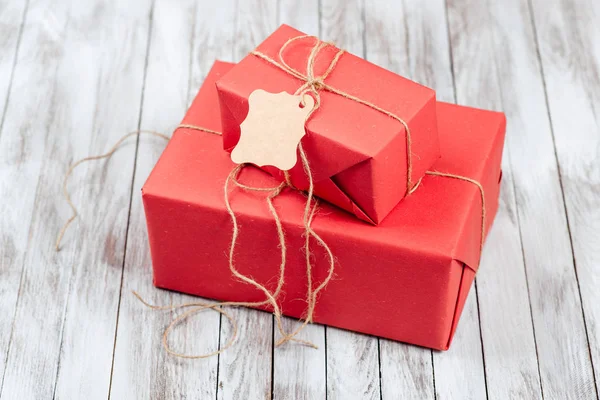 Two gift boxes with tag over wooden background. — Stock Photo, Image