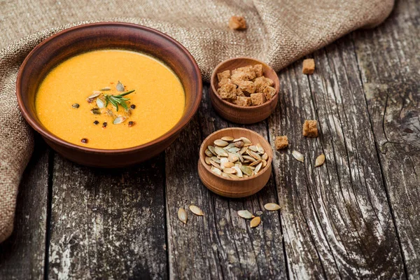 Cuenco de sopa de calabaza con pan crouton en mesa de madera oscura . — Foto de Stock