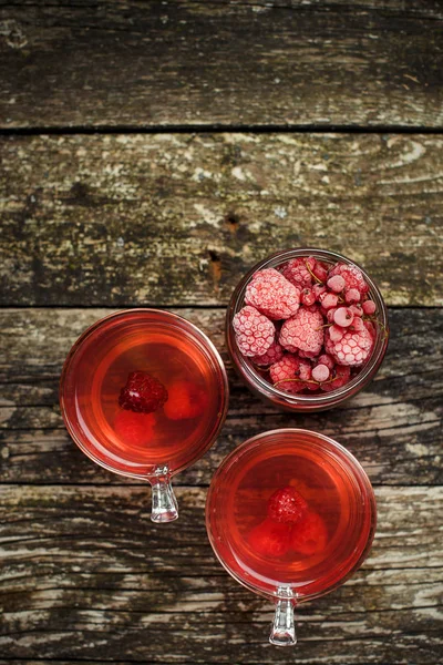 Домашний компот из замороженных ягод. Две чашки на старом ржавом деревянном фоне . — стоковое фото