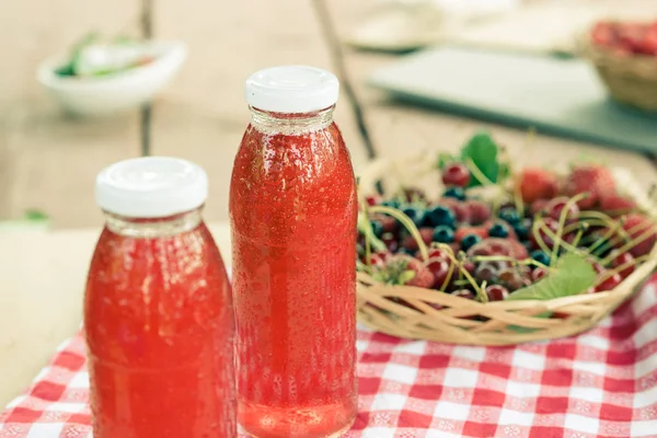 Dos botellas de fruta fría guisada de bayas variadas . —  Fotos de Stock
