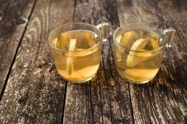 Ahşap arka plan üzerinde limonlu zencefil çayı. Seçici odak. Metin için yer.