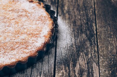 Ev yapımı pasta rustik ahşap zemin üzerine pudra şekeri serpilir. Metin için yer.