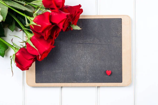 赤いバラと白い木の板に黒板の花束。テキストのためのスペース. — ストック写真