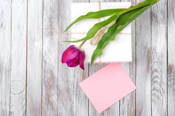 Ramo de tulipanes morados frescos y caja de regalo sobre fondo de madera. Espacio para el texto. Vista superior . — Foto de Stock