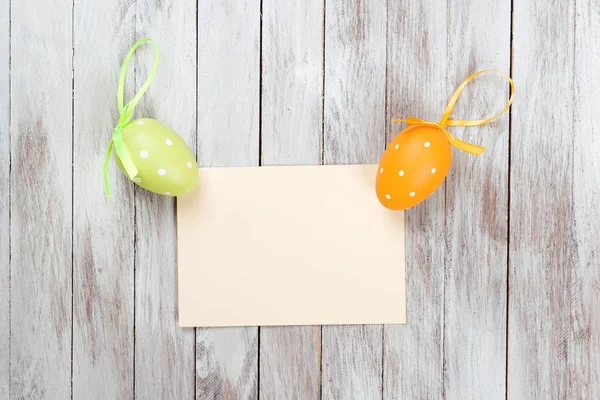 Fondo de Pascua con tarjeta en blanco sobre fondo de madera . — Foto de Stock