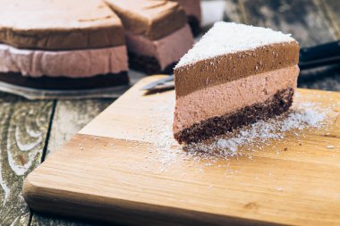 Eski ahşap artalanları Hindistan cevizi ile Çikolatalı mousse kek parçası serpilir.