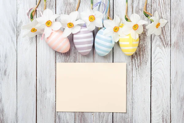 Huevos de Pascua, narcisos frescos de primavera sobre fondo de madera blanca. Tarjeta de Pascua . —  Fotos de Stock