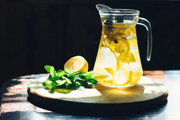 신선한 레몬에 네 한 이드 노란색 레몬과 민트 나무 부엌 배경에 항아리에 물 해독. — 스톡 사진