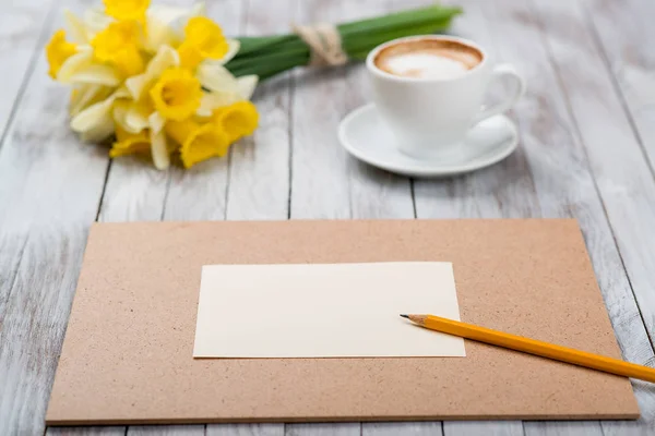 Filiżankę kawy obok wiosenne białe kwiaty na drewniane tekstury — Zdjęcie stockowe