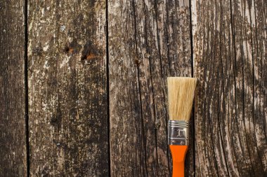 Koyu ahşap arka plan üzerinde bir boya fırçası.