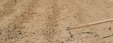 Alan ve el ile ilkbaharda dikim için kazma taze sürülmüş.