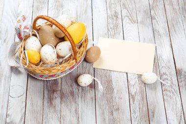 Rustik ahşap plakalar üzerinde Sepette yumurta. Paskalya kartı boş beyaz levha ile .