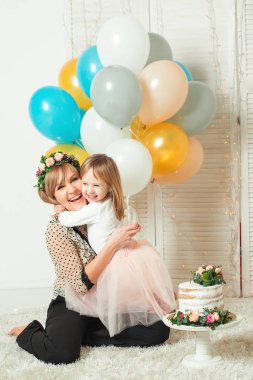 Küçük kızının oynarken mutlu anne. Doğum günü kavramı. Anneler günü kavramı.