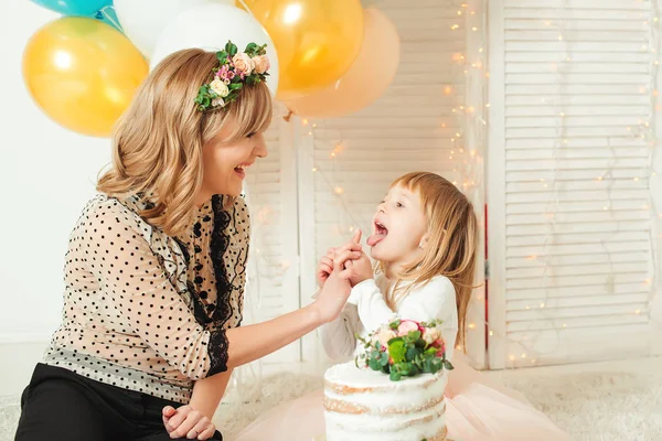 Küçük kızının oynarken mutlu anne. Doğum günü kavramı. Anneler günü kavramı.