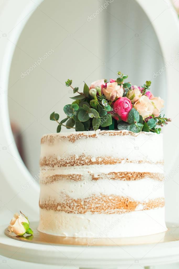 Decorated white naked cake rustic style for weddings, birthdays and events.