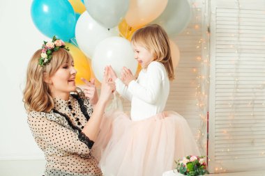 Küçük kızının oynarken mutlu anne. Doğum günü kavramı. Anneler günü kavramı.