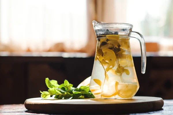 Limonata fresca in vaso con limone giallo e menta su fondo cucina in legno. Disintossicazione dell'acqua . — Foto Stock