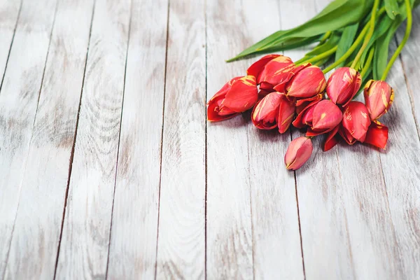 Bellissimo bouquet di tulipani rossi su sfondo di legno. Spazio per il testo. Focus selettivo . — Foto Stock