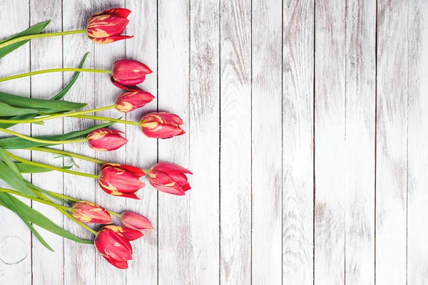 Bellissimo bouquet di tulipani rossi su sfondo di legno. Spazio per testo . — Foto Stock