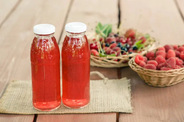 Two bottles of cold stewed fruit from assorted berries.