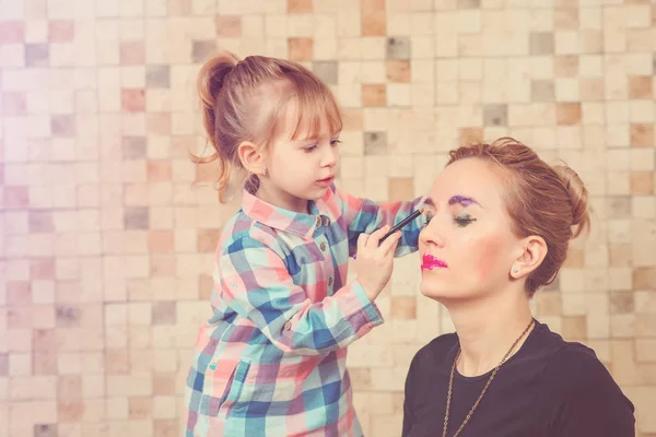 Sevimli küçük kız güzel annesi için makyaj yapıyorsun. Tonda. — Stok fotoğraf