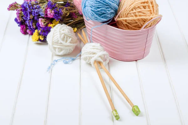 Вязание пряжи шары и иголки на белом деревянном фоне . — стоковое фото