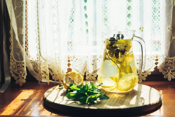 신선한 레몬에 네 한 이드 노란색 레몬과 민트 나무 부엌 배경에 항아리에 물 해독. — 스톡 사진