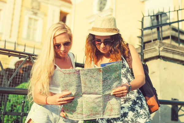 Due attraenti turisti donna guardando la mappa della città. Va Va — Foto Stock