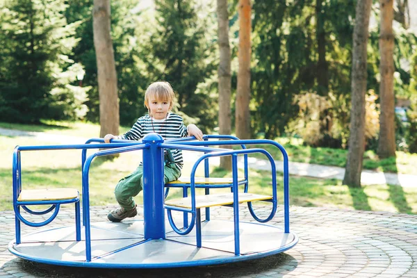 Милый счастливый ребенок. Мальчик играет на детской площадке в парке . — стоковое фото