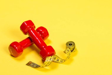 İki kırmızı dumbbell ve Sarı zemin üzerine sarı bant.