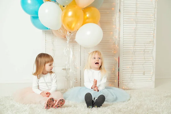 Милые маленькие девочки в платьях играют вместе в светлой комнате. С днем рождения! . — стоковое фото
