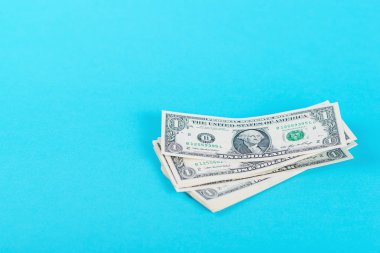 Kavram tasarruf, finans, ekonomi. Bir dolarlık banknot izole mavi artalanları.