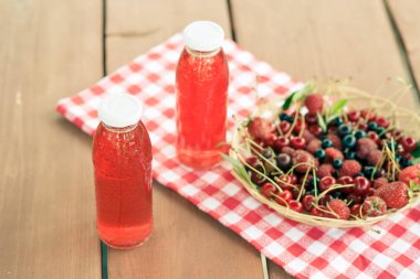 Two bottles of cold stewed fruit from assorted berries. clipart