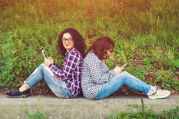 Dos mujeres jóvenes usando tableta al aire libre . —  Fotos de Stock