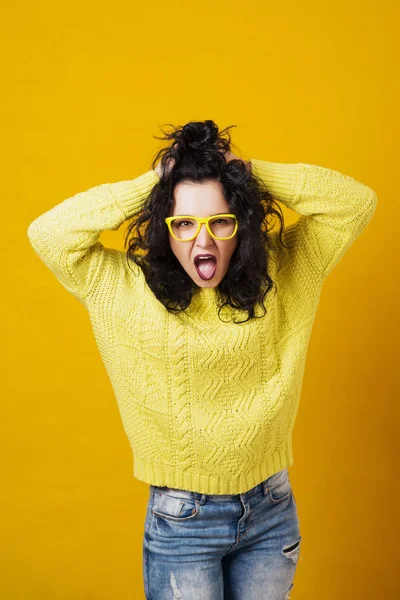 Retrato de uma jovem irritada sobre o fundo do estúdio amarelo . — Fotografia de Stock