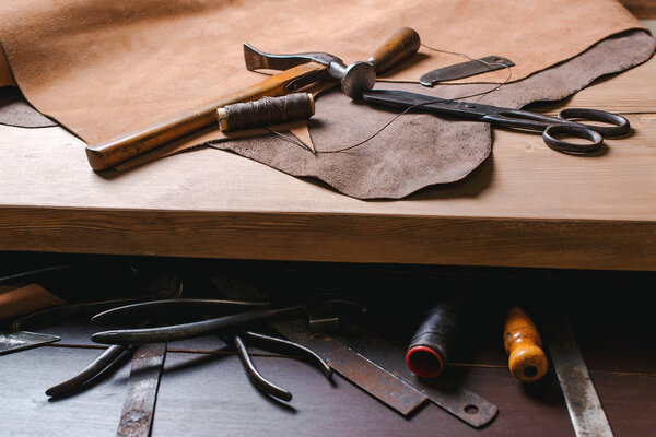 Cobbler tools in workshop on the wooden table . Top view.