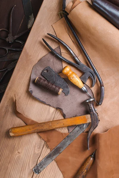 Herramientas de zapatero en taller sobre la mesa de madera. Vista superior . — Foto de Stock